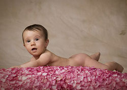 Cute picture of naked baby girl on a bed of roses taken by a Tuscaloosa, Alabama photographer.